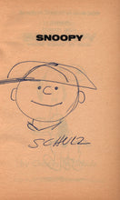 Load image into Gallery viewer, The front flyleaf featuring an original hand-drawn sketch of a smiling Charlie Brown wearing his trademark baseball cap in blue ballpoint pen, with the signature Schulz written directly below.