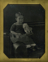 Load image into Gallery viewer, Full-length view of the half-plate daguerreotype showing a seated three-year-old girl holding a toy dog under glass