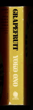 Load image into Gallery viewer, Close-up view of the perfect-bound spine, showing the printed black-and-white titles and the sun-fading.